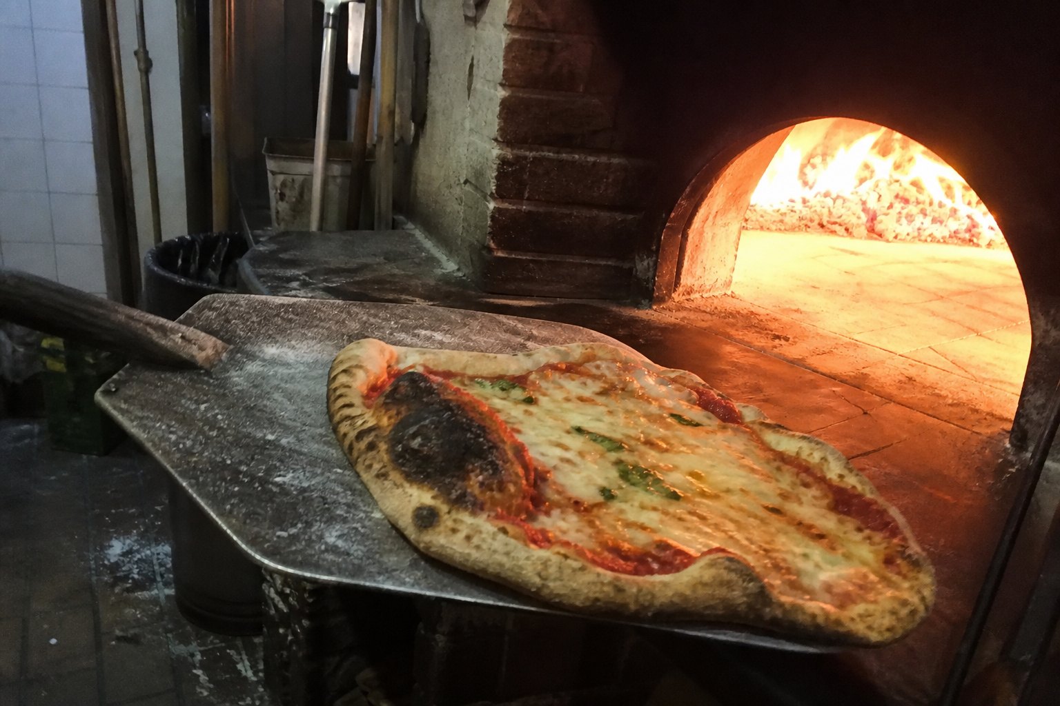 Pizza on a peel, at the oven.