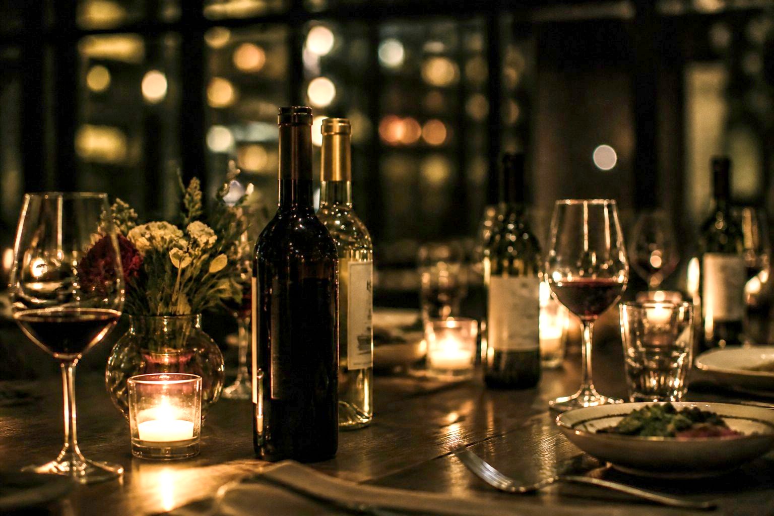 Wine bottles and candles on the table.