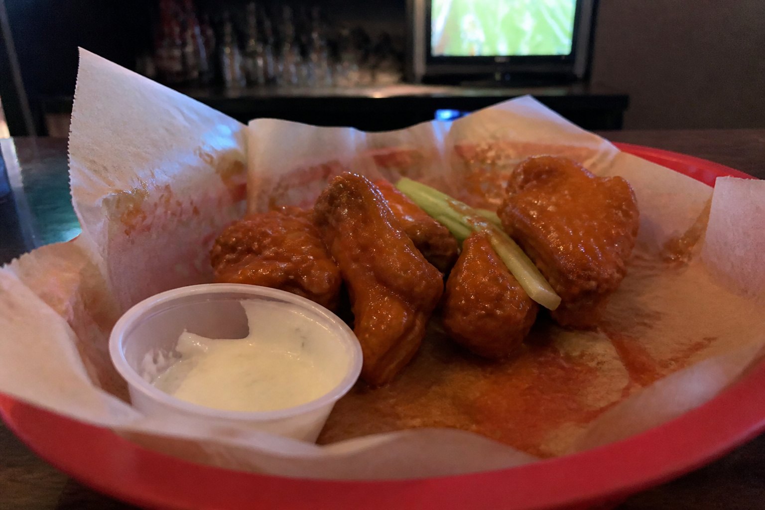 Wings with ranch in a red basket.